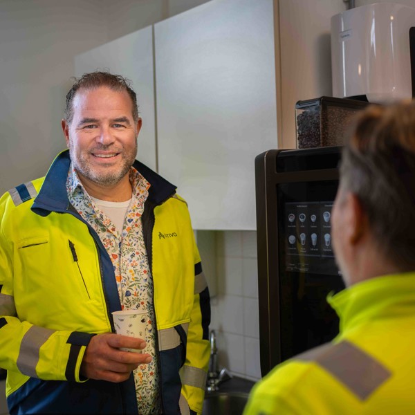 Teammanager Lars Sleijpen staat bij de koffieautomaat en lacht naar de camera Teammanager Lars Sleijpen staat bij de koffieautomaat en lacht naar de camera