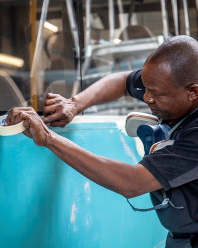 Monteur plakt bus blauwe Arriva-bus af met verftape Monteur plakt bus blauwe Arriva-bus af met verftape