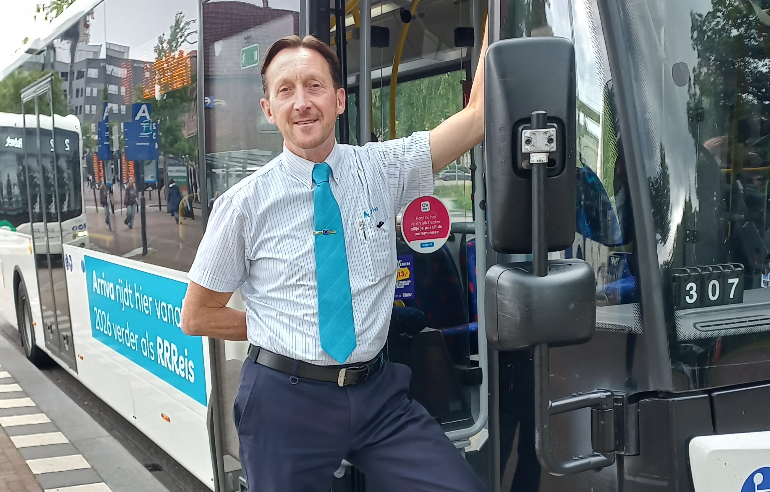 Buschauffeur Paul Jan staat in de deuropening van zijn bus.