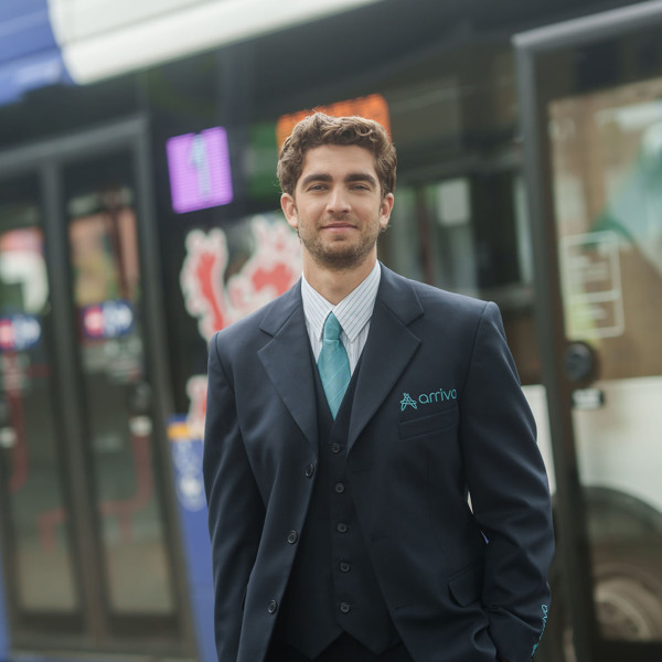Een buschauffeur in Arriva-uniform staat voor een bus, met lijnnummer 1 en Arriva duidelijk zichtbaar op de achtergrond. Een buschauffeur in Arriva-uniform staat voor een bus, met lijnnummer 1 en Arriva duidelijk zichtbaar op de achtergrond.