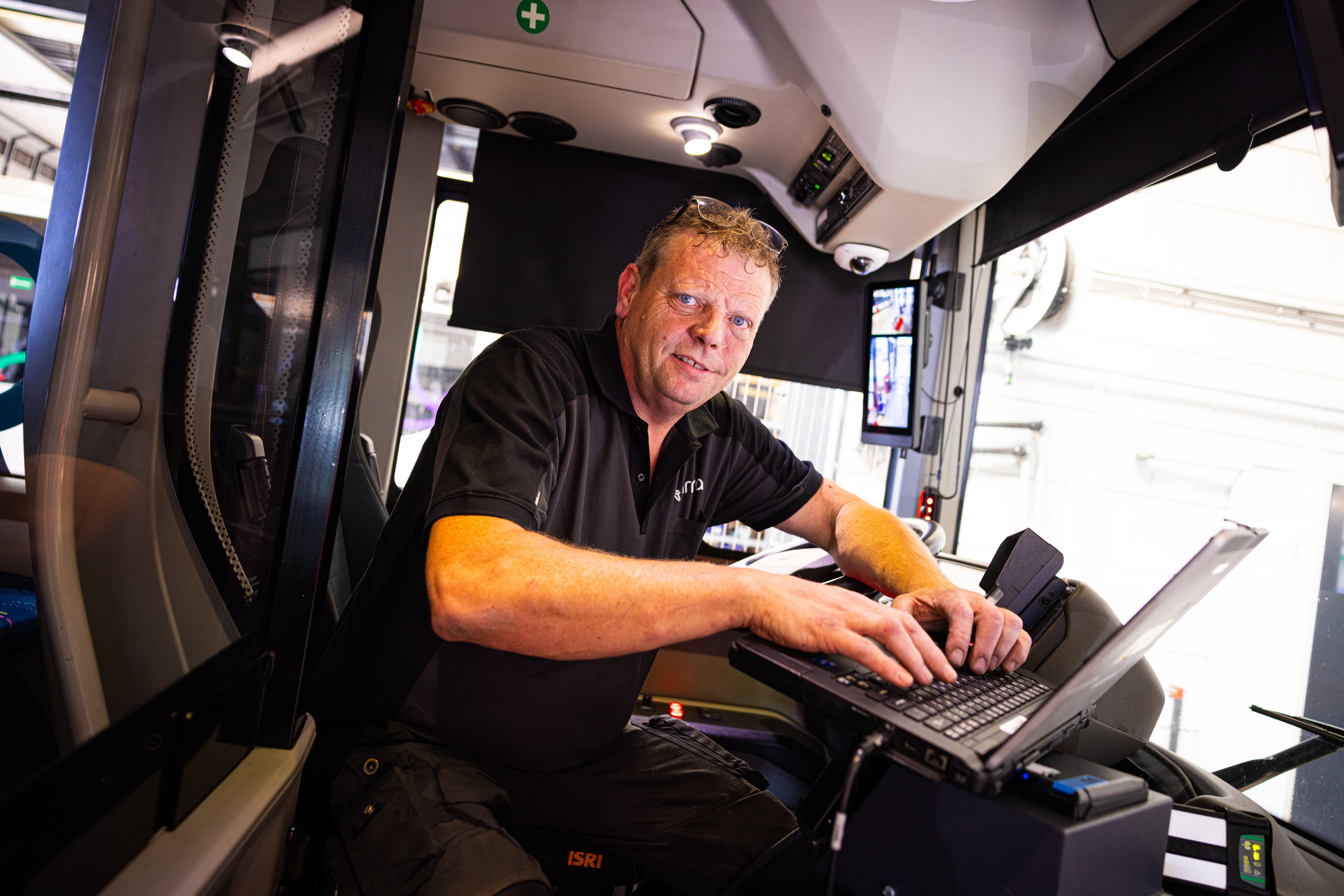 Monteur met de laptop op het stuur van de bus