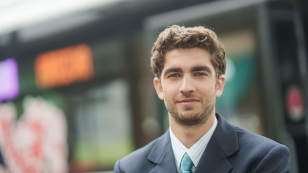 Buschauffeur van Arriva staat voor zijn bus en kijkt de camera in. Buschauffeur van Arriva staat voor zijn bus en kijkt de camera in.