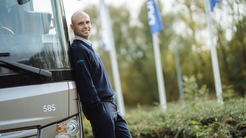 Chauffeur van Arriva leunt relaxt tegen touringcar. Chauffeur van Arriva leunt relaxt tegen touringcar.