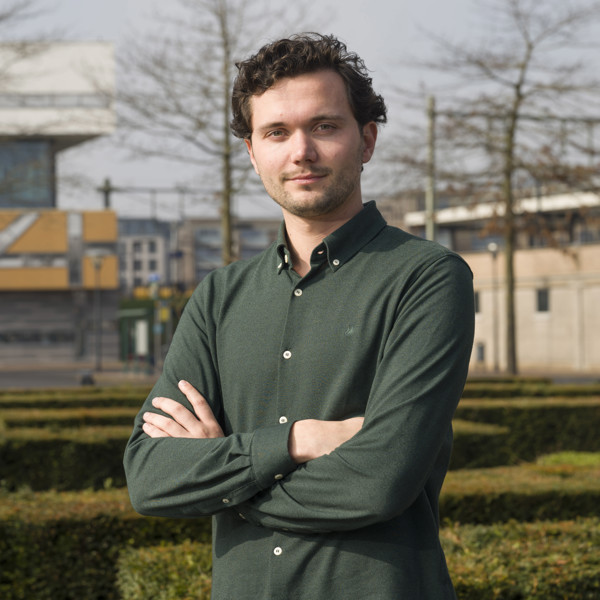 Man staat buiten voor een stedelijke achtergrond met zijn armen over elkaar Man staat buiten voor een stedelijke achtergrond met zijn armen over elkaar