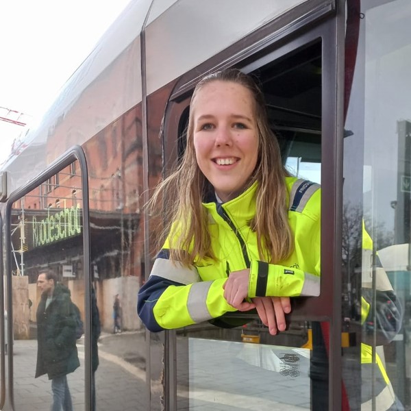 Treinmachinist in opleiding Nadine leunt uit het raampje van een Arriva-trein en lacht. Treinmachinist in opleiding Nadine leunt uit het raampje van een Arriva-trein en lacht.