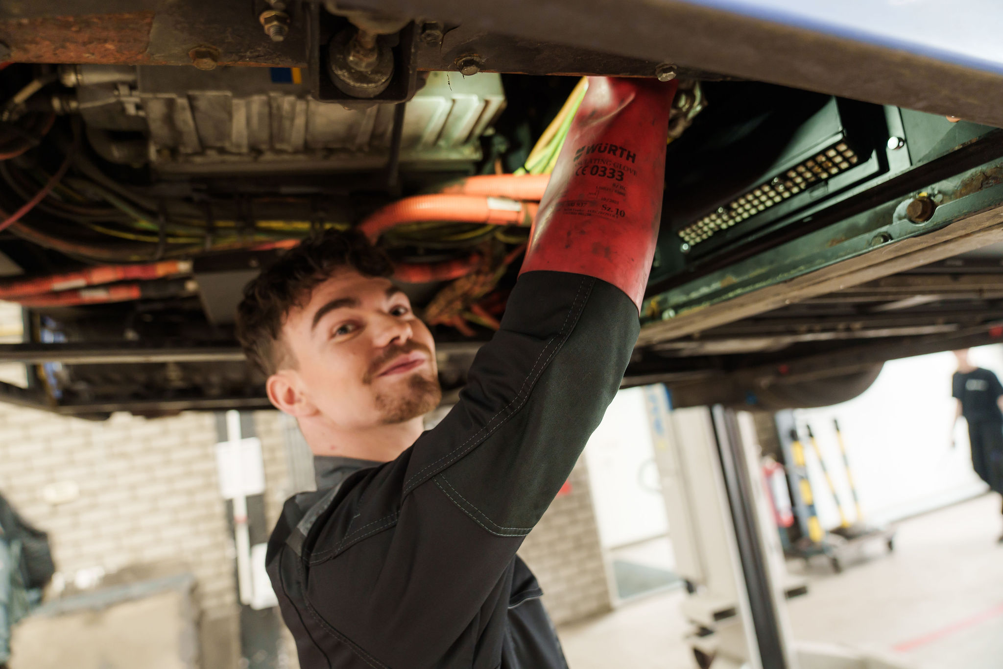 Monteur van Arriva sleutelt aan de onderkant van een bus.
