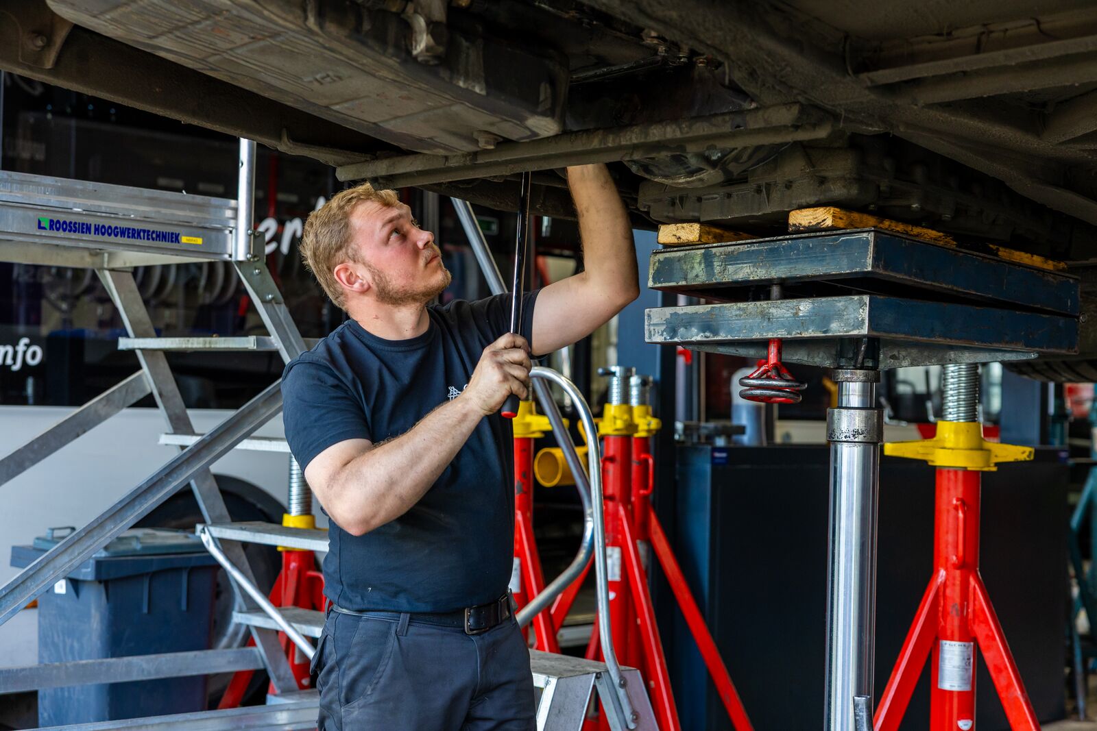 Monteur sleutelt aan onderkant Arriva-bus.