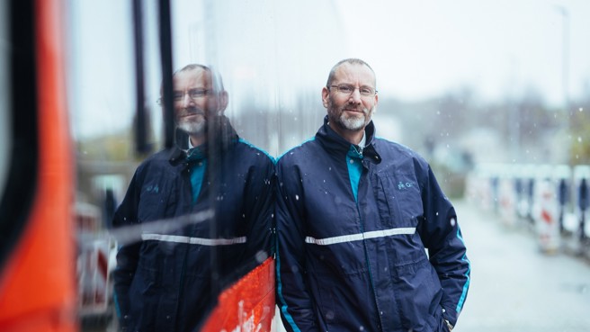 Buschauffeur Eric leunt in Arriva-uniform en tegen zijn bus aan terwijl het sneeuwt. Buschauffeur Eric leunt in Arriva-uniform en tegen zijn bus aan terwijl het sneeuwt.