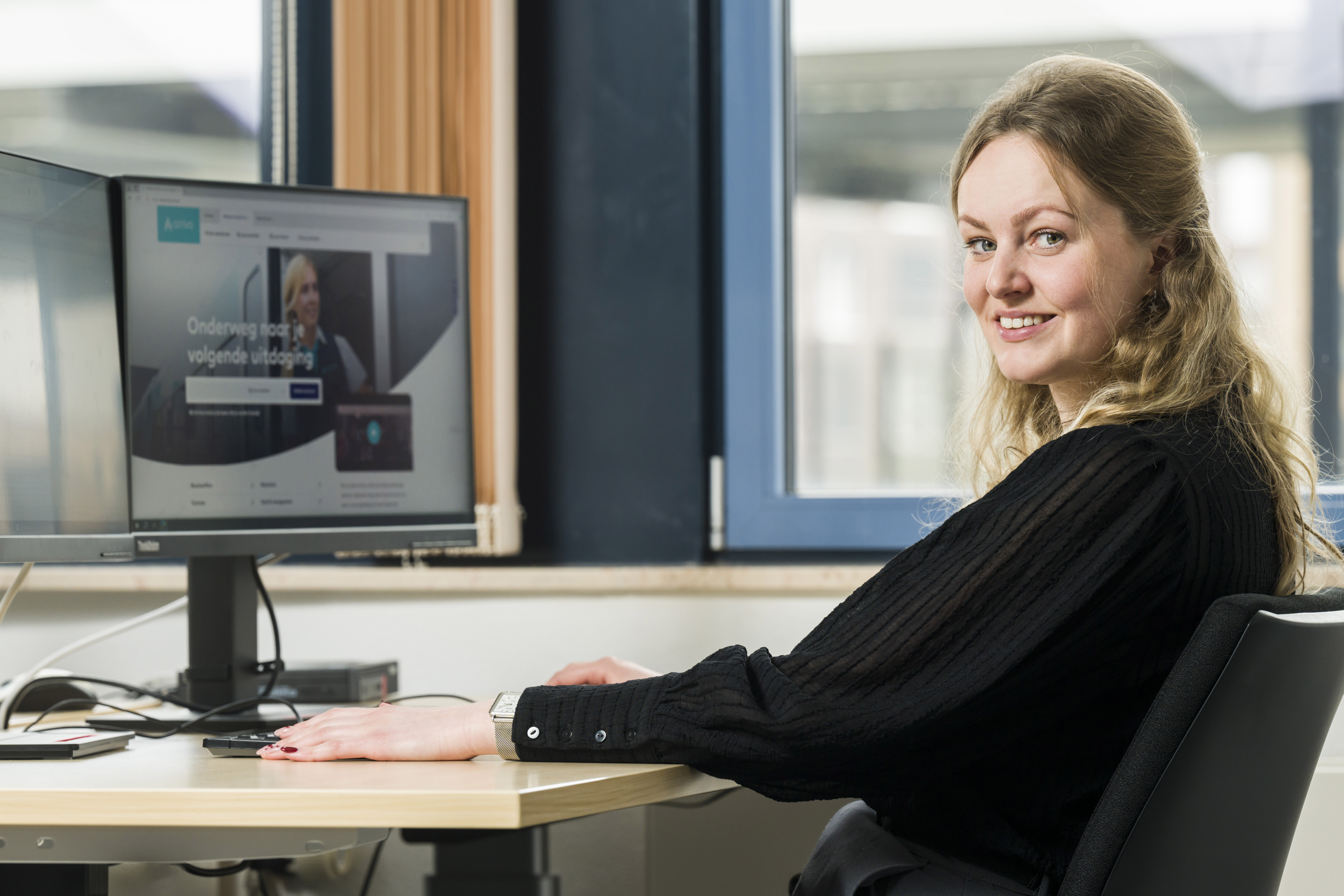 Een vrouw zit achter een computer met de homepagina van werkenbijarriva.nl open