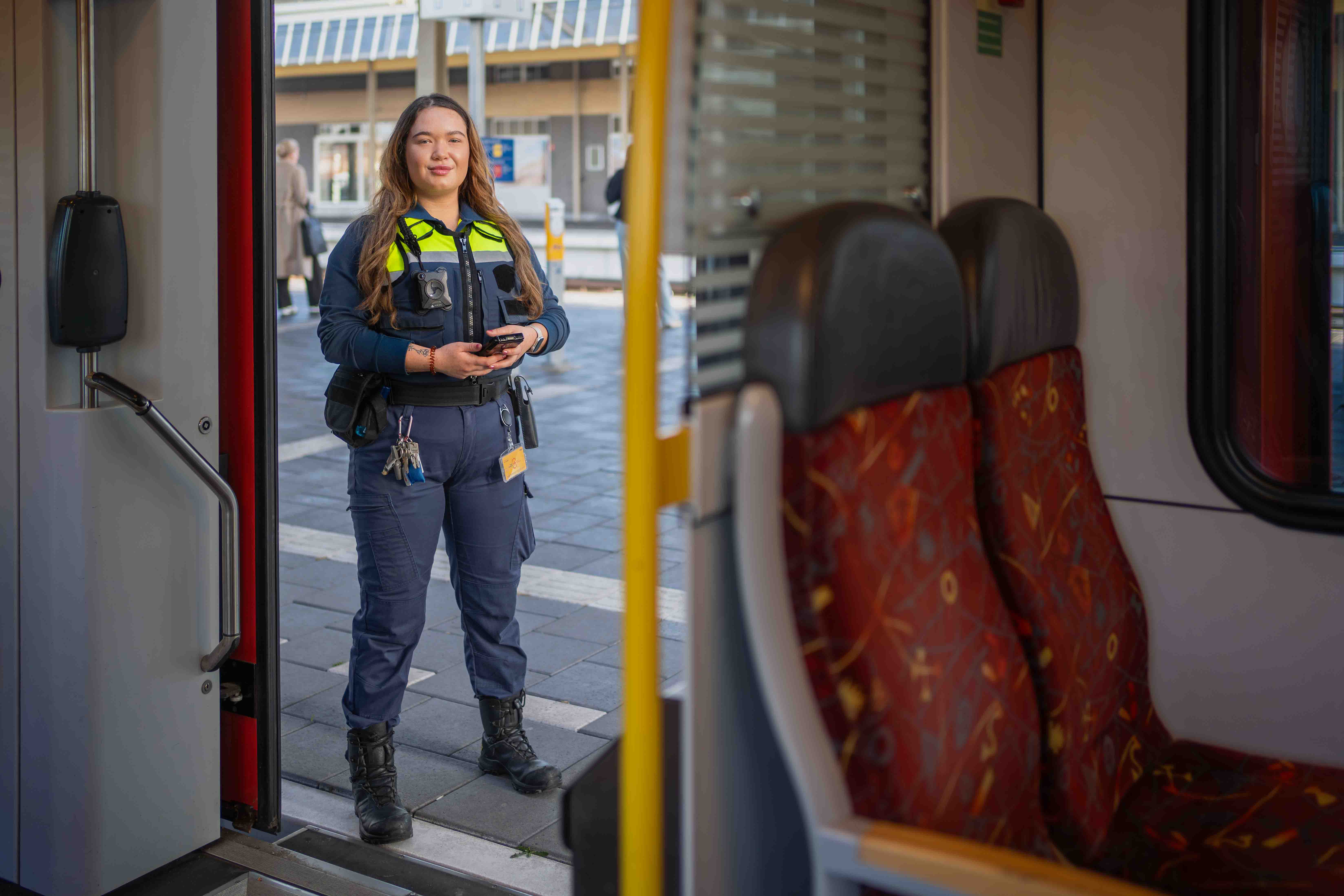 Jonge vrouw staat zelfverzekerd in de deuropening van een Arriva-trein 