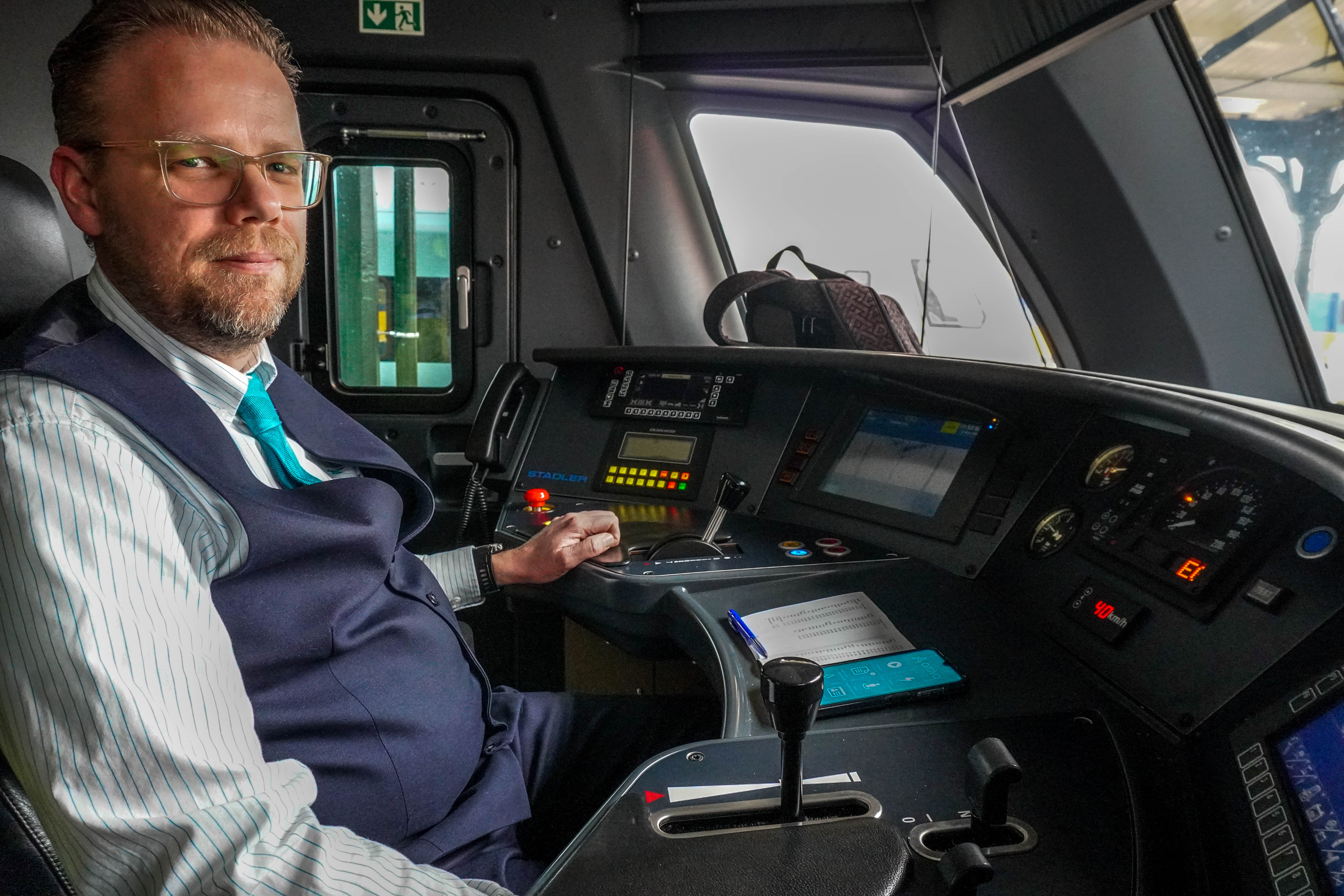 Aspirant machinist Simon van Holst zit achter het bedieningspaneel van een trein.