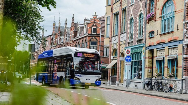 Blauw-witte bus van Arriva rijdt langs kleurige gebouwen in Venlo. Blauw-witte bus van Arriva rijdt langs kleurige gebouwen in Venlo.