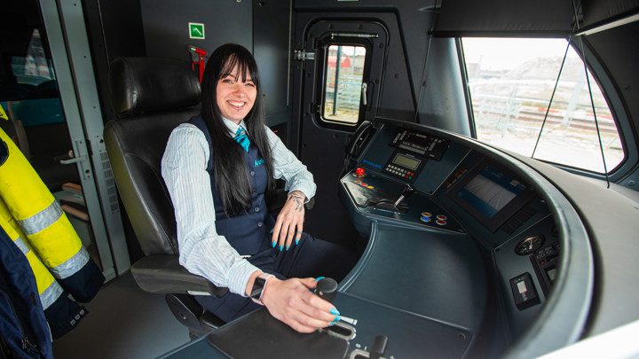 Machinist Shannon zit in haar Arriva-uniform achter het bedieningspaneel van een trein. Machinist Shannon zit in haar Arriva-uniform achter het bedieningspaneel van een trein.