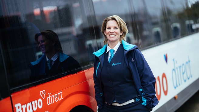 Buschauffeur Katja staat lachend naast haar Arriva-bus. Buschauffeur Katja staat lachend naast haar Arriva-bus.