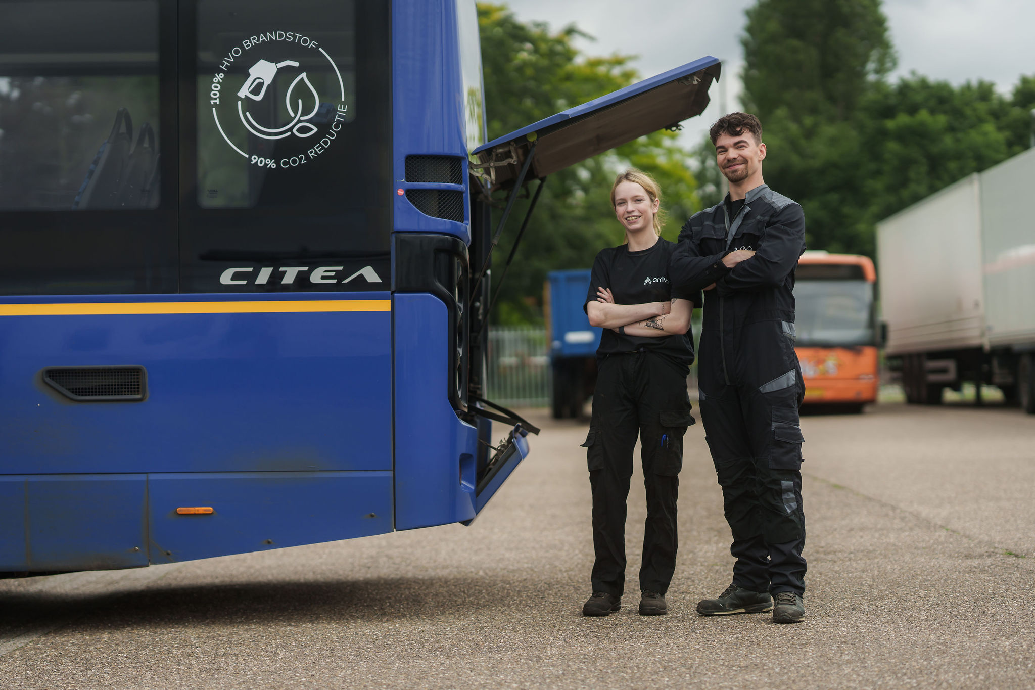 Twee monteurs van Arriva staan bij de open achterklep van een bus.