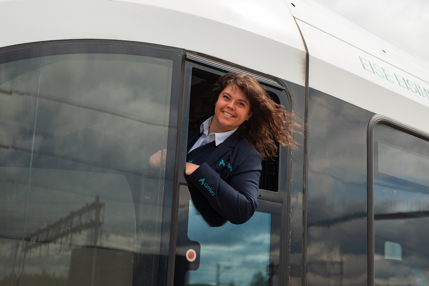 Machinist Gabriëlle Welmers hangt lachend uit het raam van haar cabine.