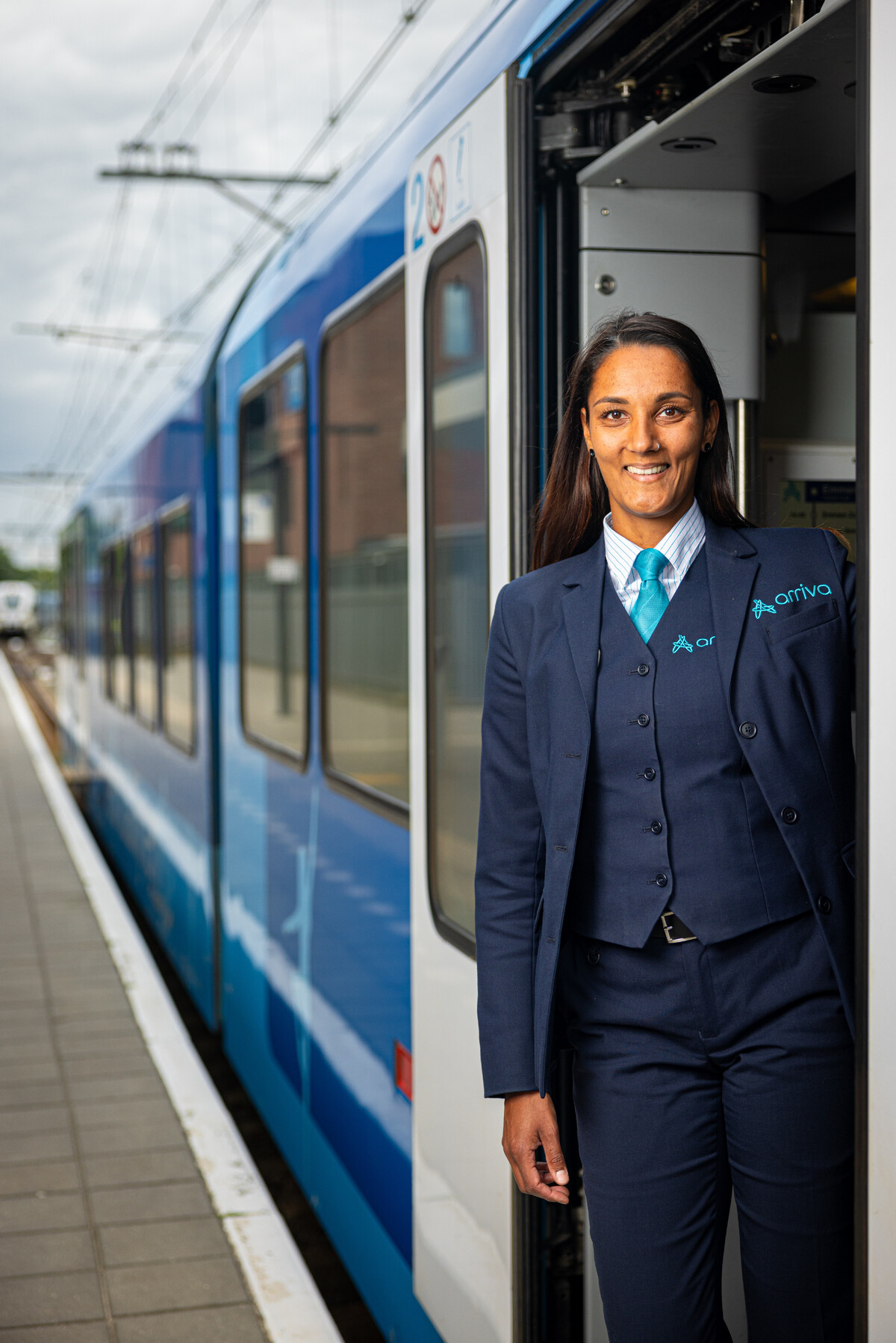 Steward Jamila staat in de deuropening van een trein van Arriva.